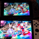A photo displaying the standard Nintendo Switch's screen with the OLED Switch in a side-by-side comparison where the OLED screen is noticeably brighter.